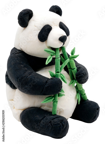 Charming clay panda bear sculpture enjoying a meal of fresh green bamboo stalks