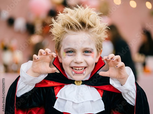 Happy young boy in vampire costume for Halloween party celebration