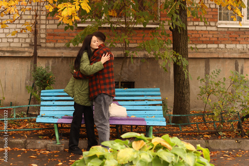 Foto Young couple embracing tenderly on a park bench during autumn