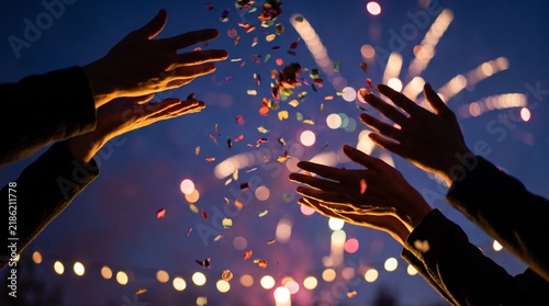 People Throwing Confetti Under Fireworks Display at Night Celebration