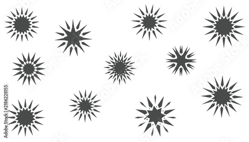 Seamless pattern of abstract geometric sunburst or starburst shapes scattered across a white background.