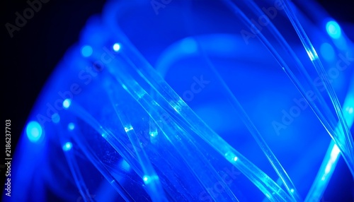 Close up of blue glowing fiber optic cables for high speed data transmission