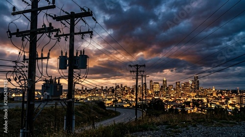 City Skyline at Dusk with Power Lines and Dramatic Sky