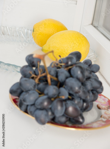 Black grapes and two lemons.
