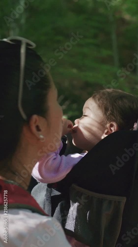 Multiethnic family hiking in the forest with a baby carrier
