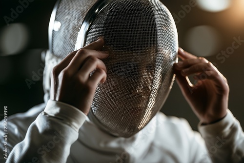 Fencing Athlete Adjusting Mask Before a Match in Indoor Gym