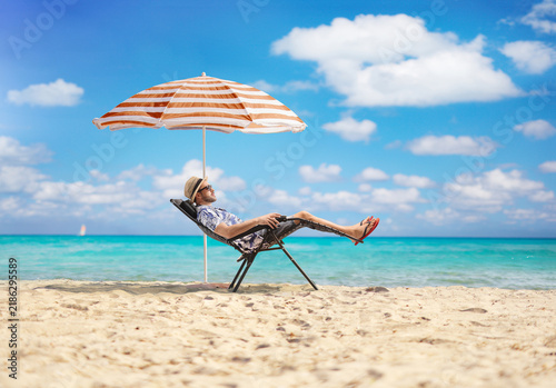 Bild auf Leinwand Man relaxing in a reclining beach chair