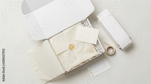 Open white cardboard shipping box with tissue paper and blank note cards