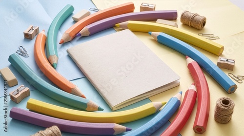 Blank Notebook Mockup with Curved Colorful Pencils Swirl School Stationery Flat Lay Stock Photo