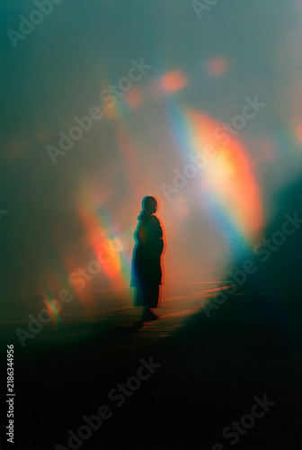 Mystical Silhouette of a Person in Profile Illuminated by a Vibrant Diagonal Rainbow Light Beam, Creative Film Grain Portrait