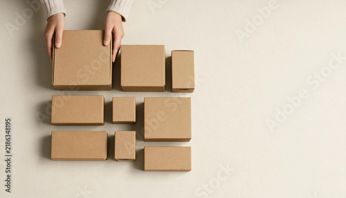 Top view of a person organizing different sizes of brown cardboard shipping boxes with cardboard box package delivery e commerce shipping online business parcel shipment box collection