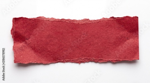 A torn piece of red paper on a white background