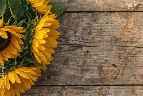 Vibrant sunflowers arranged on a rustic wooden table, showcasing their bright yellow petals and rich brown centers.