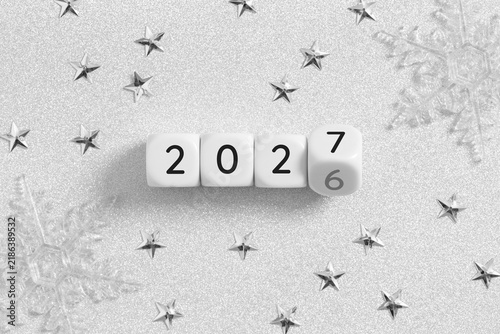2026 changing to 2027 on dice with christmas glitter silver background for new year change concept