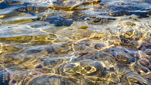 Gentle ripples create a mesmerizing pattern on the clear water surface, reflecting light beautifully.