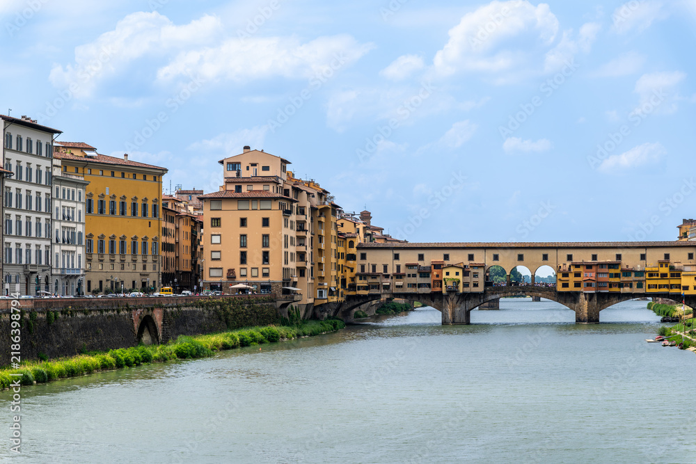 Fototapeta premium Ponte Vecchio, a famous medieval stone arch bridge that spans the Arno River in Florence, Italy