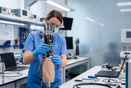 Professional Biomedical Engineer Meticulously Assembling Advanced Robotic Prosthetic Hand Device In A Modern Sterile High Tech Laboratory