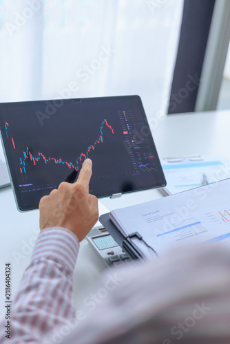 Businessman working on screen monitoring stock market to analyze data and investment portfolio trends.