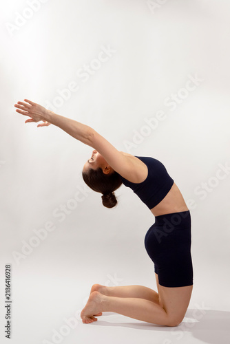 Woman Performing Camel Pose Yoga on Neutral Background