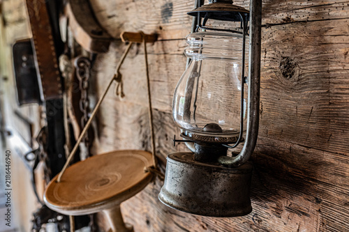 Canvastavla Close-up of vintage kerosene lamp hanging on rustic wooden wall in dim light