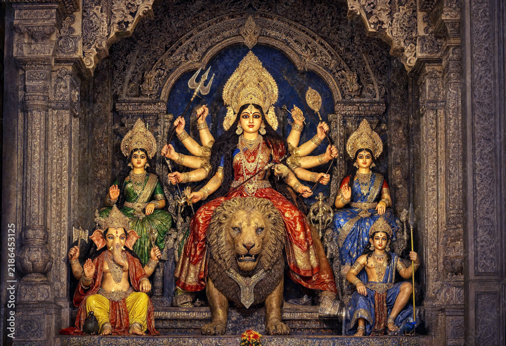 Obraz premium Colorful Hindu goddess Durga statue with lion and deities in ornate temple setting