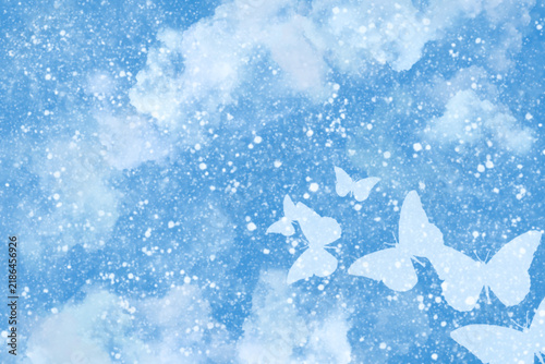 Light blue sky background featuring soft watercolor clouds sparkling glitter dust and white silhouette butterflies perfect for spring banners headers and gentle nature designs