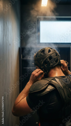 Rugby Player in Locker Room Adjusting Headgear