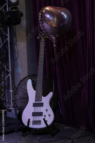 Guitar stands next to a balloon in a music venue during an event at night