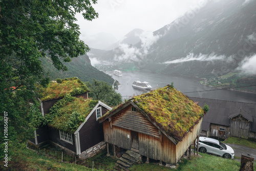 Принти на полотні Traditional Norwegian sod roof houses overlooking Geirangerfjord with cruise ships