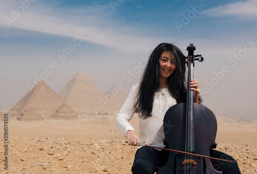 Obraz na płótnie Young Middle Eastern woman cellist performing with joyful smile before the iconi