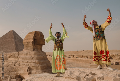 фотографія Two men in ornate embroidered traditional costumes raise arms in exuberant cultu