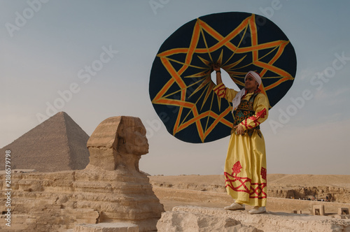 Cuadro en lienzo Proud Egyptian folk performer in ornate yellow robe and turban lifts a bold teal