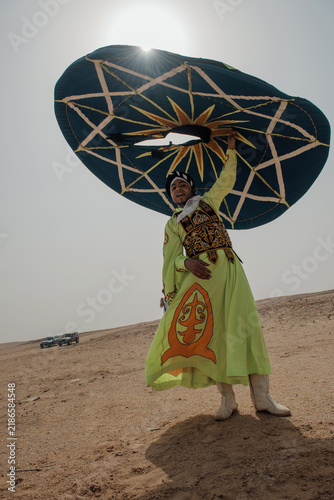 Foto Exuberant folk performer in ornate lime green embroidered robe raises a massive