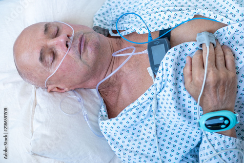 Foto elderly man with sleep apnea monitoring device and fingertip pulse oximeter, sen