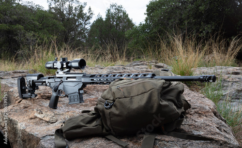Konstfotografi Highly accurate and adjustable rifle and scope on a boulder outdoors