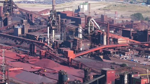 Aerial drone view of a heavy metallurgical plant producing steel. Industrial facility with manufacturing buildings and infrastructure.