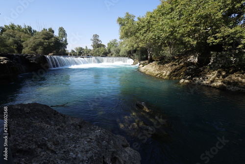 Turquoise waters of Manavgat Waterfall surrounded by lush green nature, popular tourist destination in Antalya