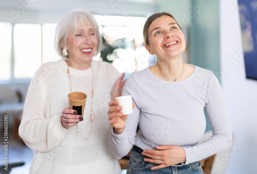 Canvastavla Two businesswomen drink coffee and discuss news during a break in the office