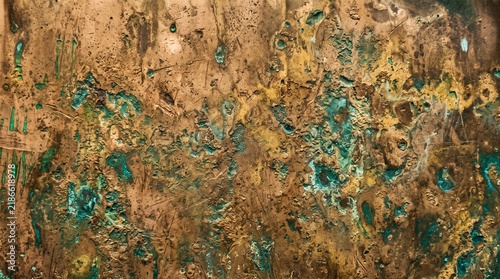 Close up of aged copper metal surface with green patina and textured imperfections