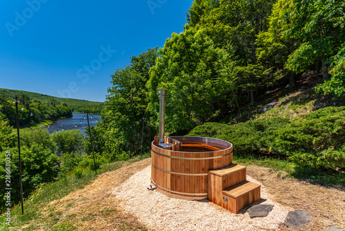 Foto Wood fired outdoor hot tub overlooking a scenic lake and green forest