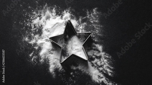star shaped cookie cutters on dark surface, contrast composition, dramatic baking still life