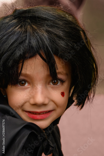 Little girl smiles shyly, eyes wide and curious
