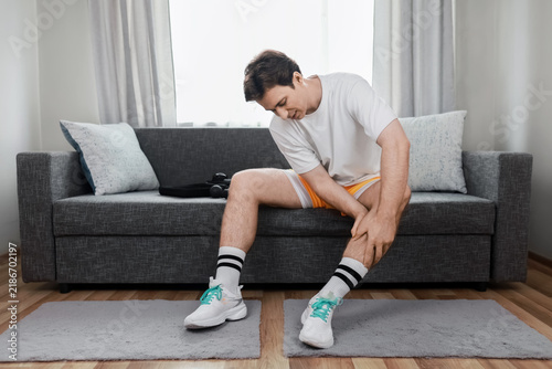 man experiences muscle tension and leg pain. For self care, he prepares for rehabilitation and recovery using percussion massage therapy and myofascial release.