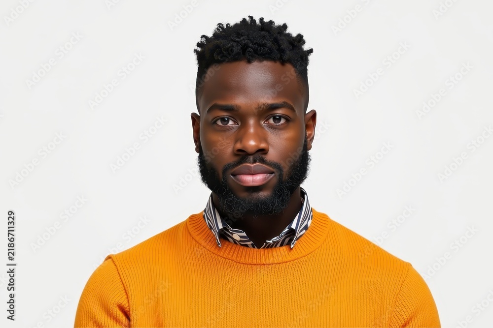 Obraz premium Portrait of a serious man wearing an orange sweater on a white background