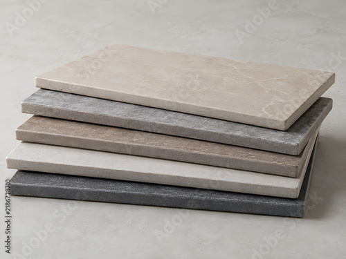 Stacked concrete slabs in various shades on a textured surface  