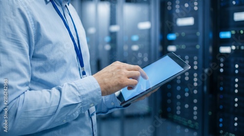 Plakat Man using digital tablet in secure cloud computing facility.
