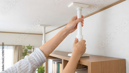 棚の上に突っ張り棒を取り付ける手元