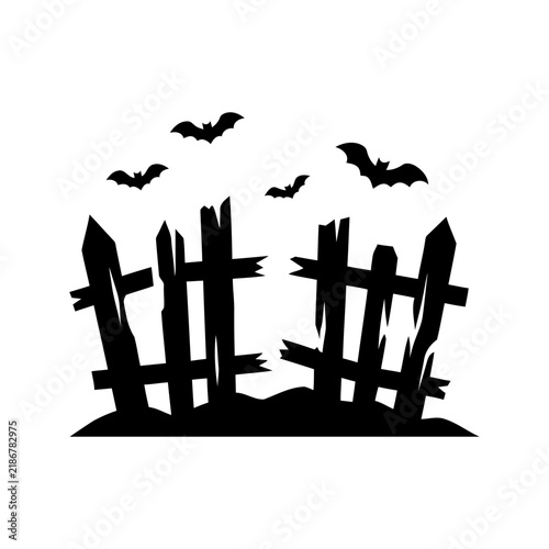 Spooky Halloween scene silhouetted fence on dark ground with flying bats suitable for holiday decorations party invitations and spooky designs.