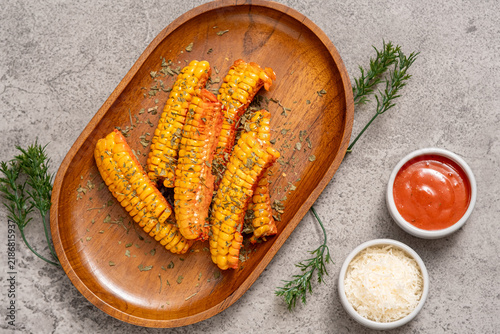фотографія Grilled corn pieces sprinkled with parsley and brushed with sauce