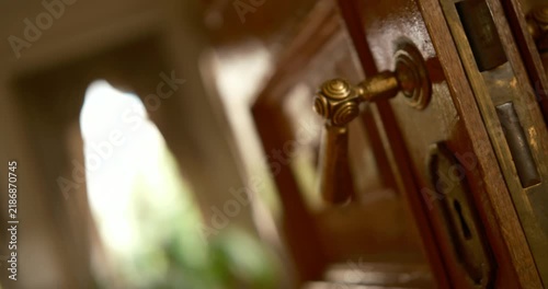 Antique brass door handle close-up, cinematic 360-degree rotating shot, ornate vintage hardware, warm golden lighting.
